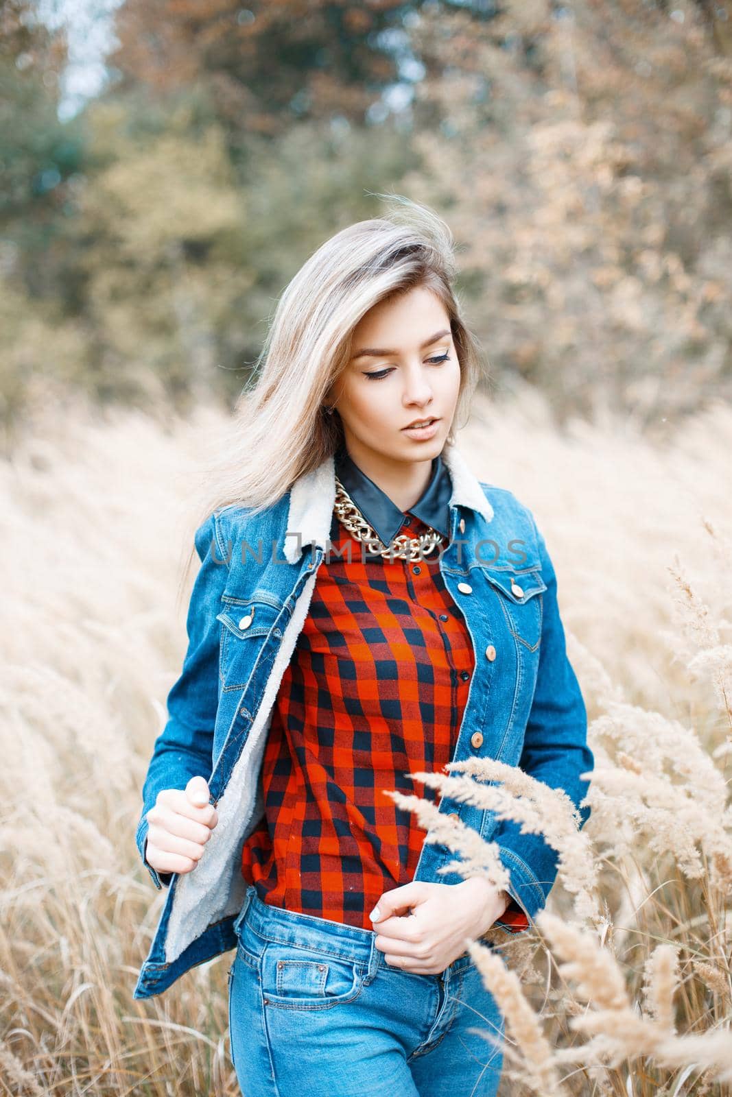 Beautiful stylish girl in denim jacket, checkered red shirt and blue jeans. by alones