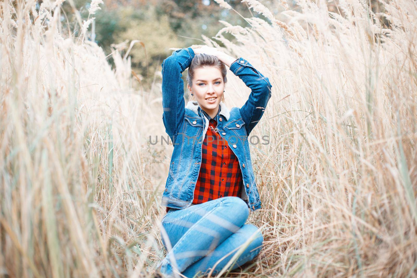 Young beautiful girl with a smile in denim clothes. by alones