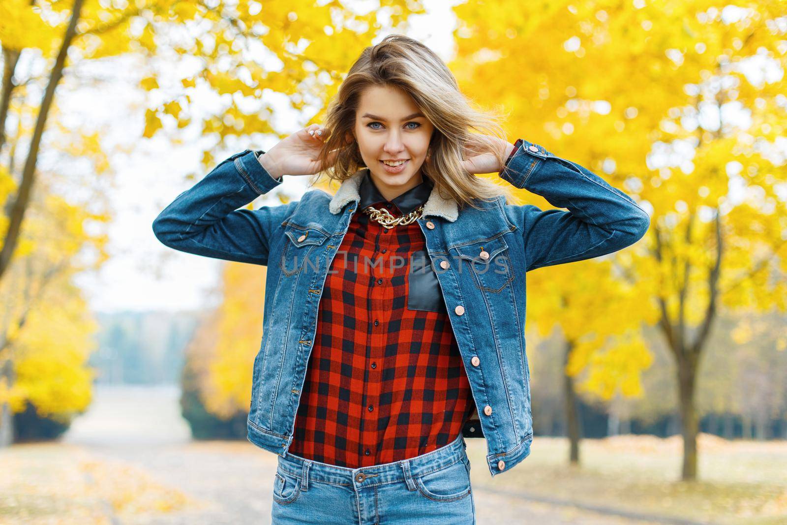 Young woman in jeans clothes in the autumn park.