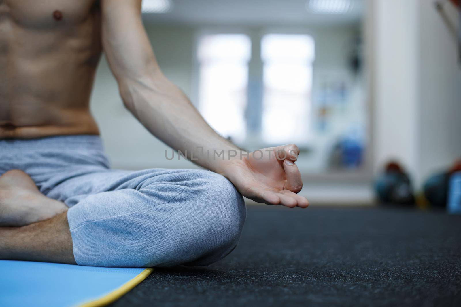 Young man in meditation on the background of the gym