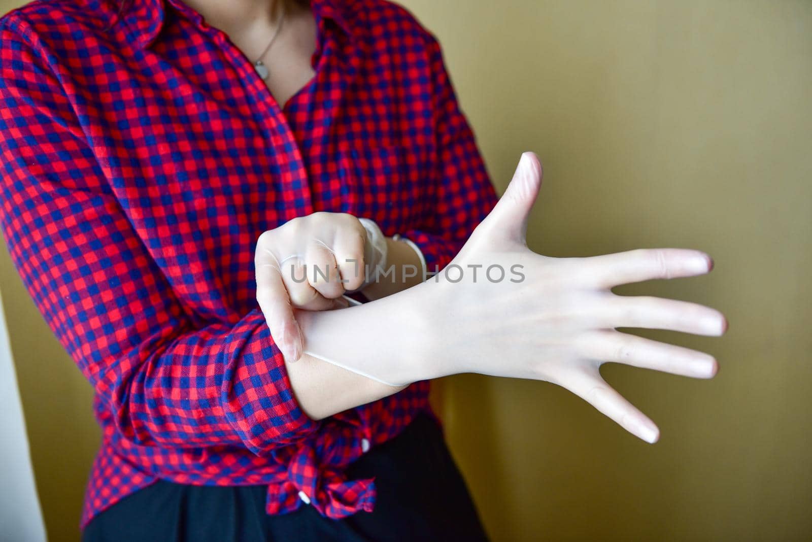 Personal protective equipment vinyl disposable gloves, woman puts her hands in gloves.