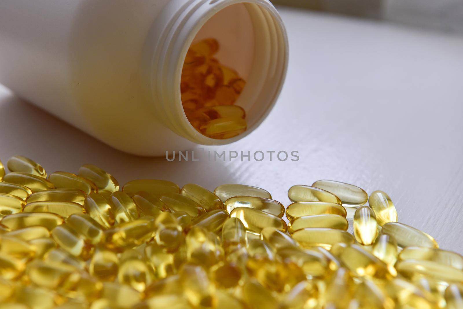 Fish oil capsules with omega 3 and vitamin D in a bottle on wooden texture, healthy diet concept,close up shot.