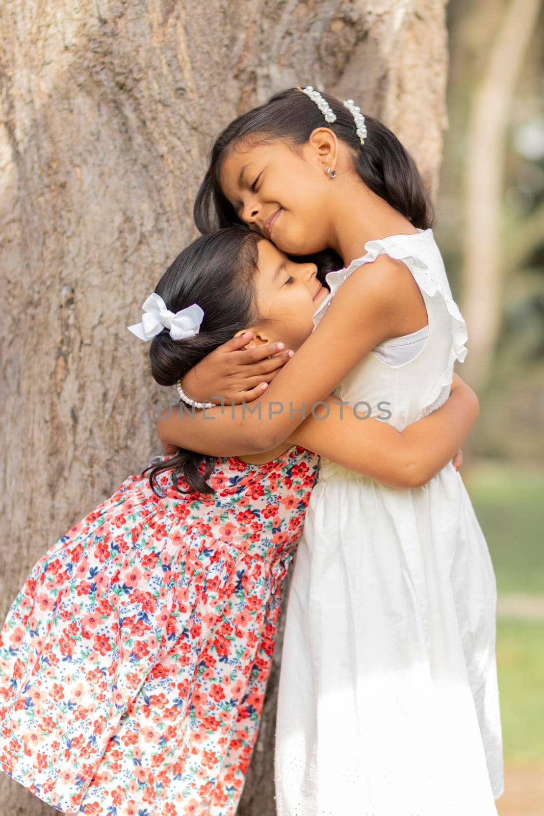 Tender little sisters hugging each other and showing their true love