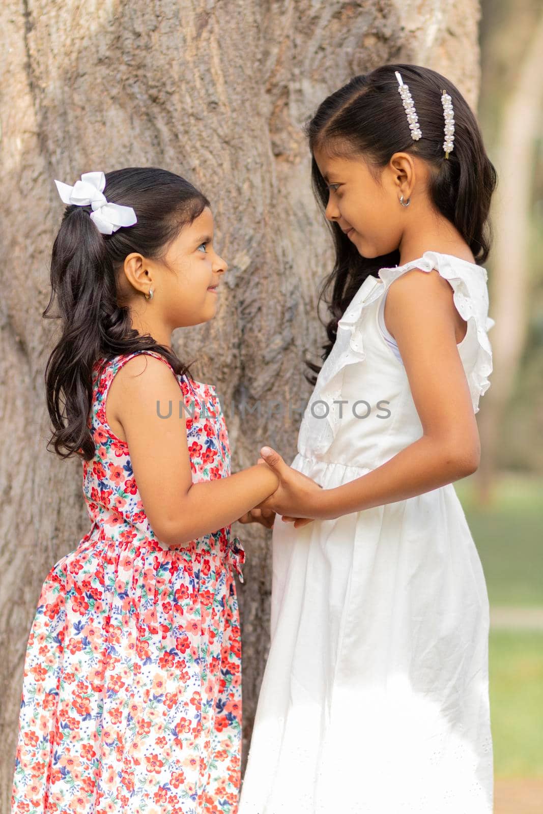 Tender little sisters hugging each other and showing their true love