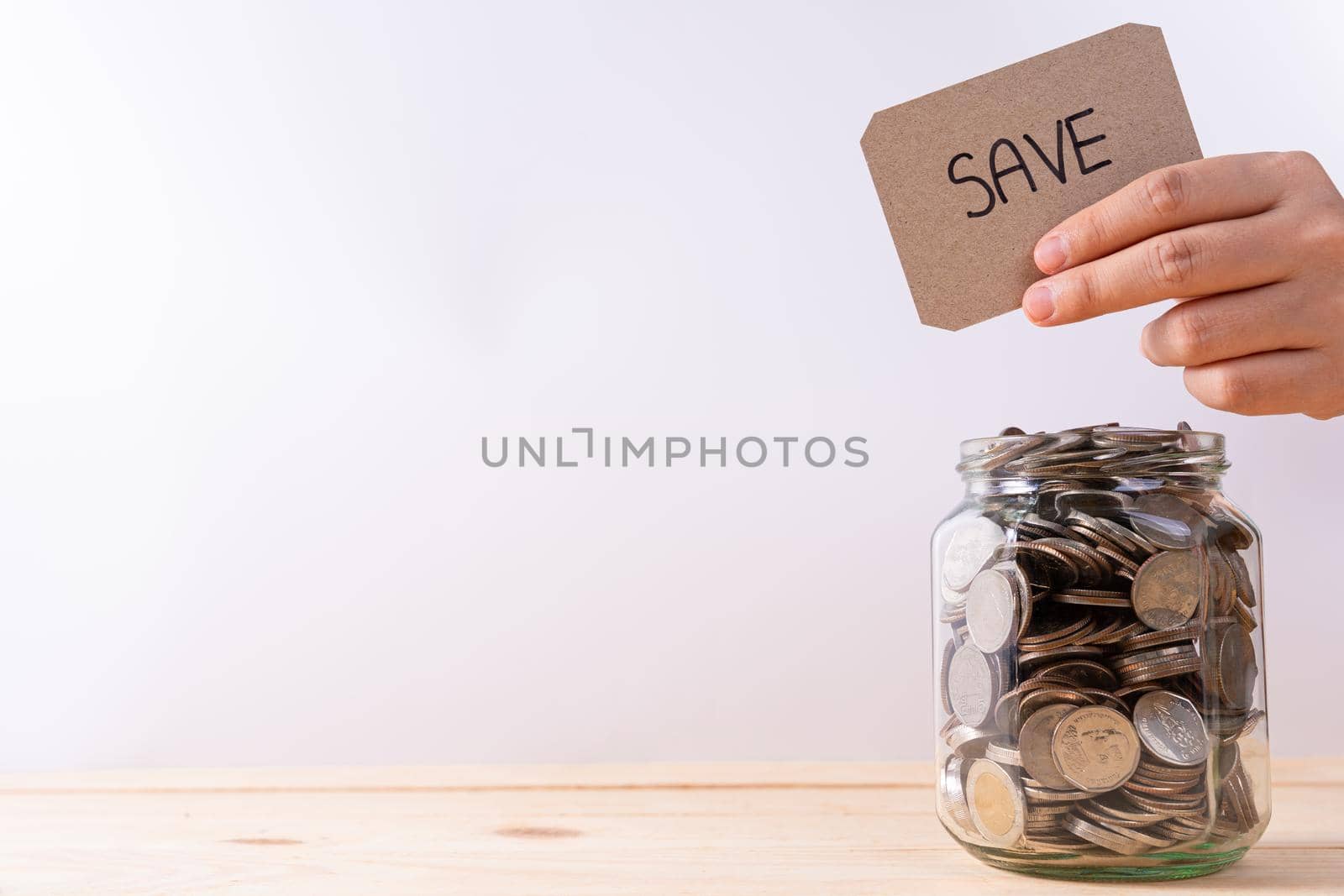 Jar full of coins with travel word paper on wooden table isolated grey background. Saving money and investment concept. by mikesaran