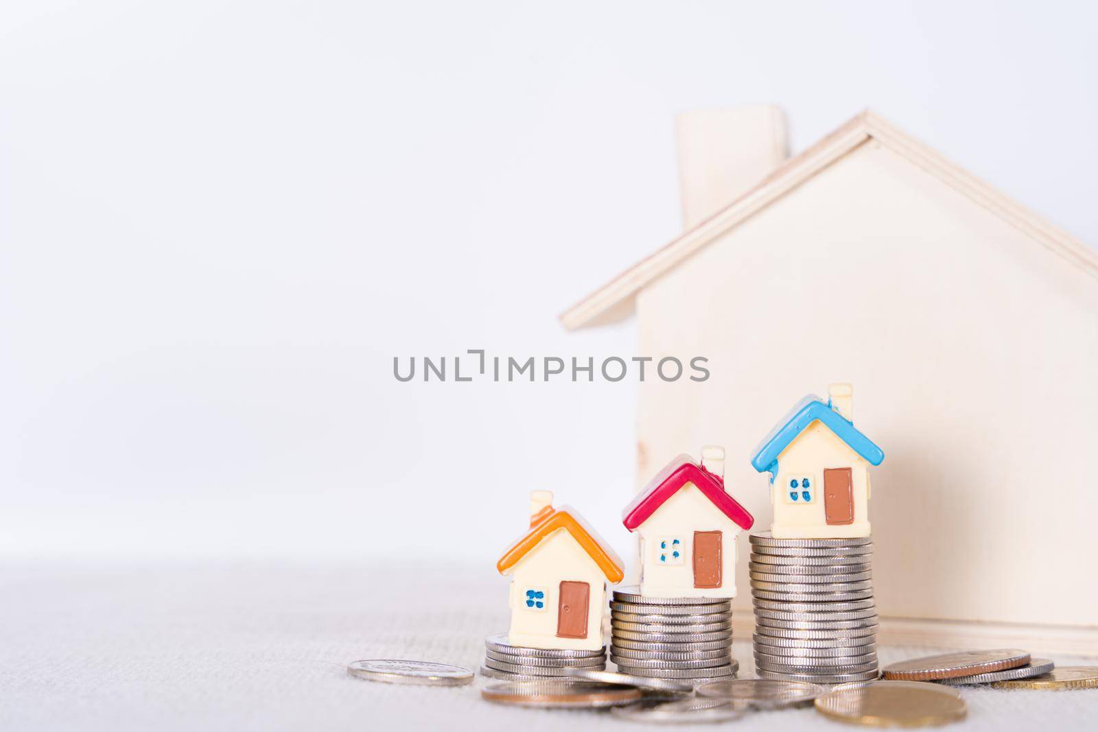House and stack coins isolated grey background. Property investment and house mortgage financial concept.