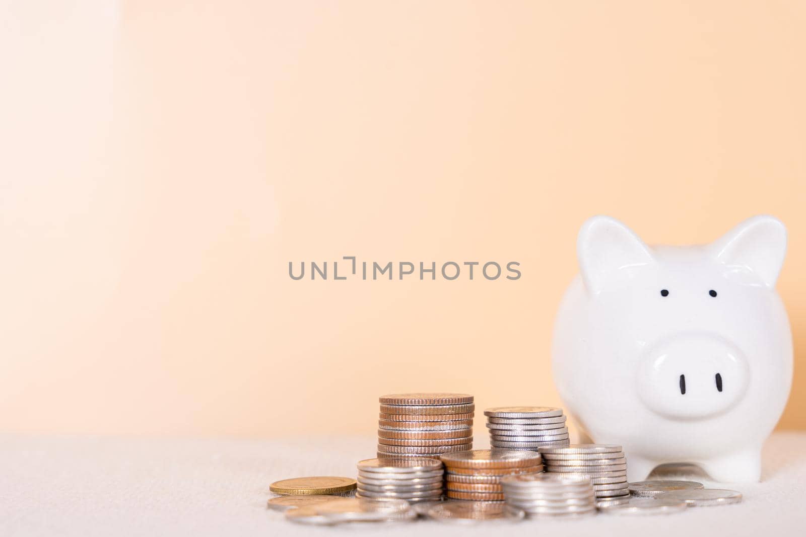 Piggy bank with stack coins isolated orange background. Saving money and investment concept. by mikesaran