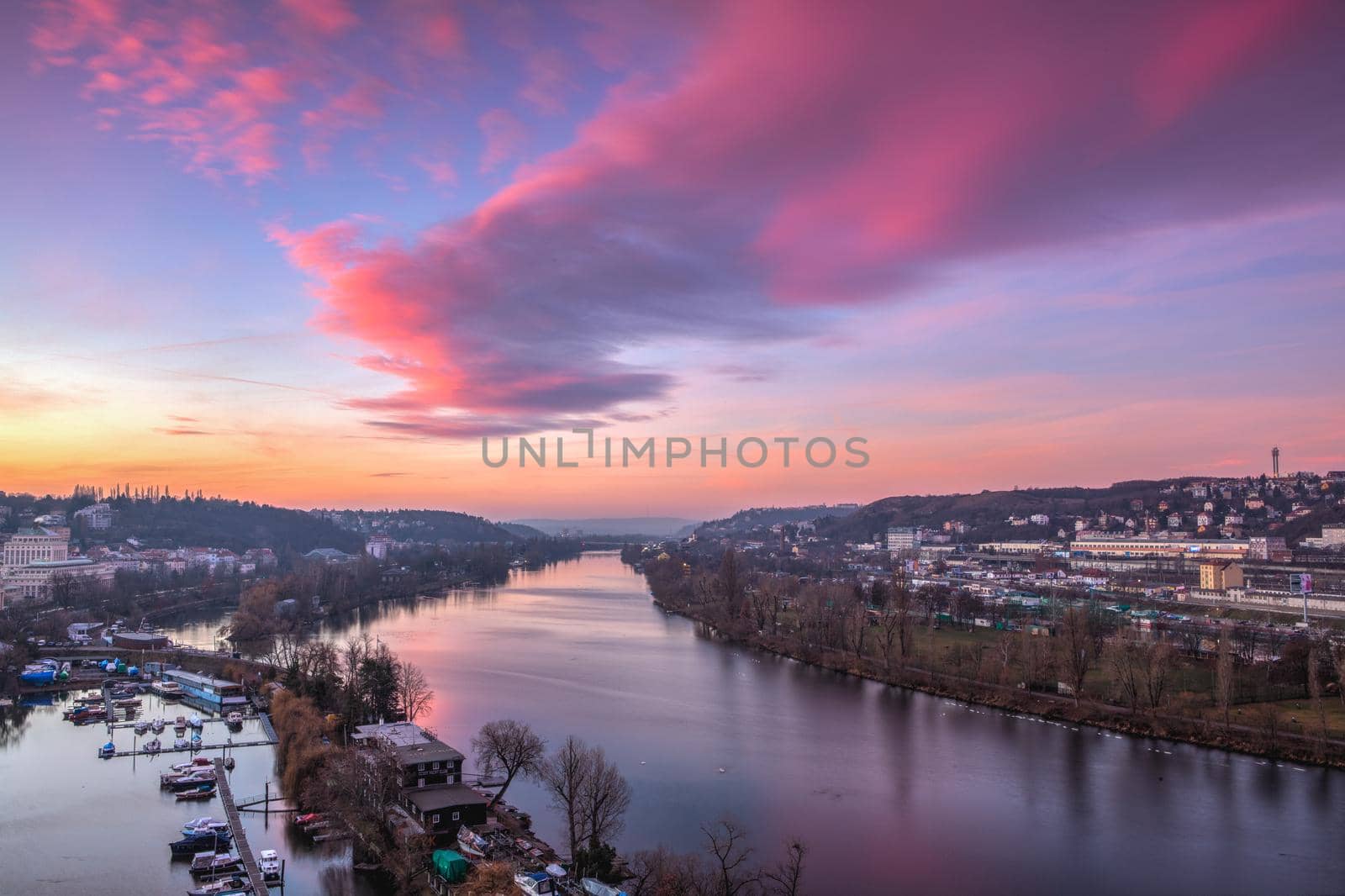 Small dock, boats and Vltava River in Prague, Czech Republic, viewed from the Vysehrad fort in the pink sunrise. Vysehrad is a historic fort located in the city of Prague. It was built probably in the 10th century.