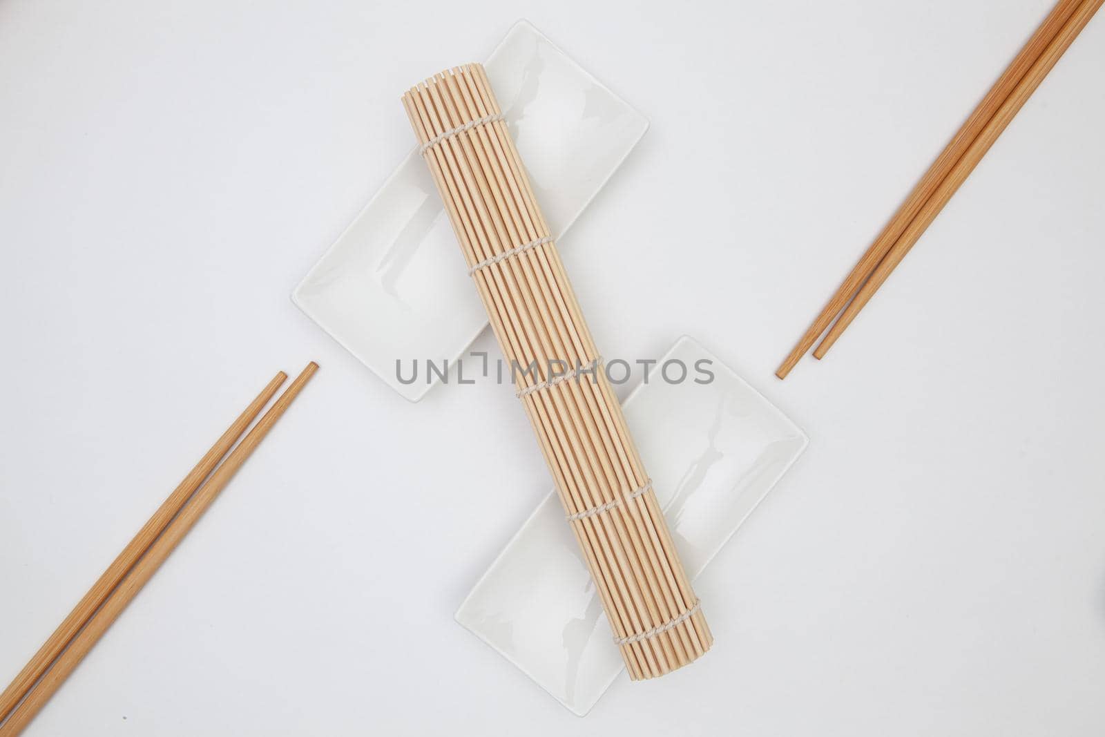 Top View Of White Empty Sushi Plates With Bamboo Chopsticks and Mats.  by CaptureLight