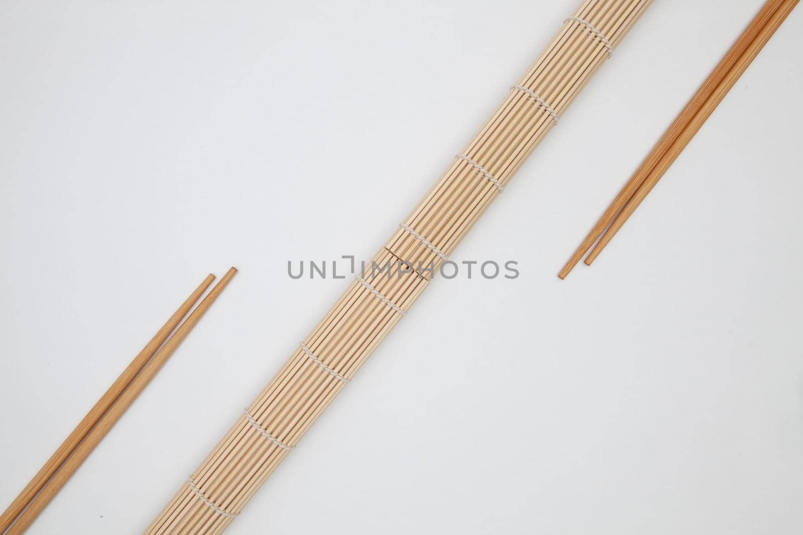 Bamboo mat with chopsticks for sushi on the white table. Food Design