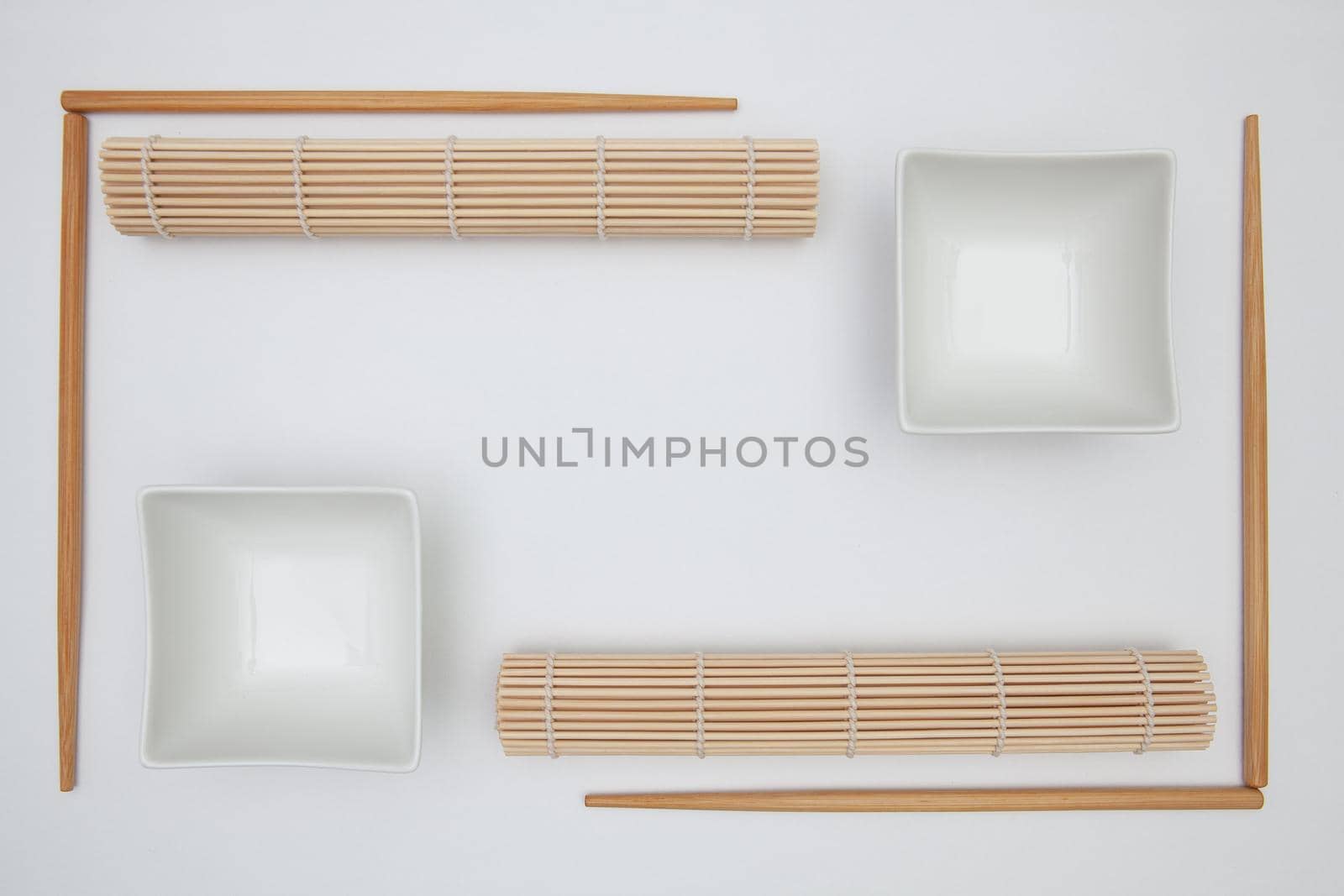 Top View Of White Empty Sushi Plates With Bamboo Chopsticks and Mats. Symmetry Food Design