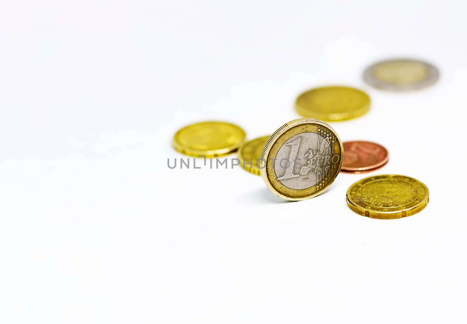 One euro coin standing together with various coins isolated on a white background. Economics and finance. European union currency