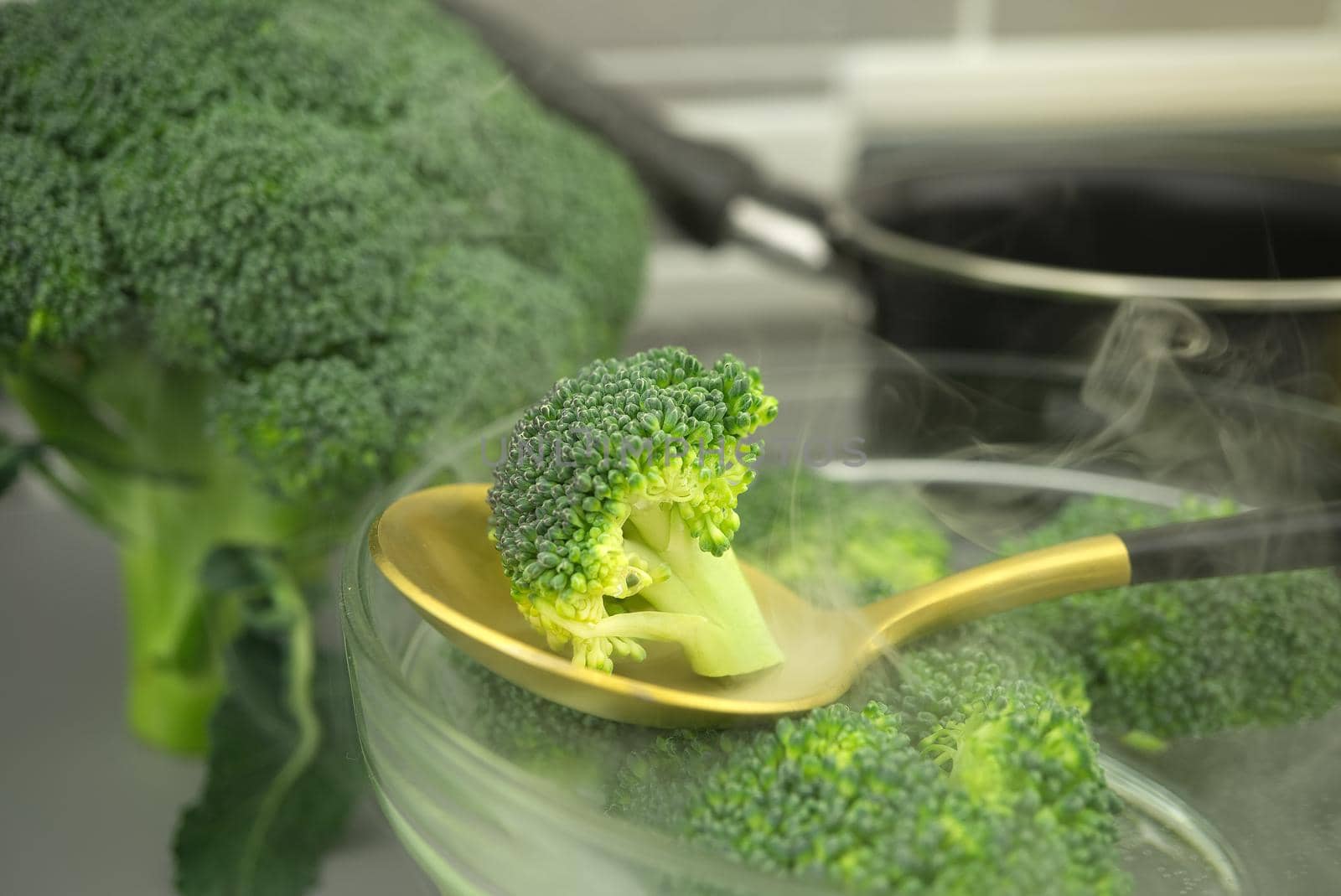 Fresh broccoli on a spoon, preparation for cooking on the kitchen table