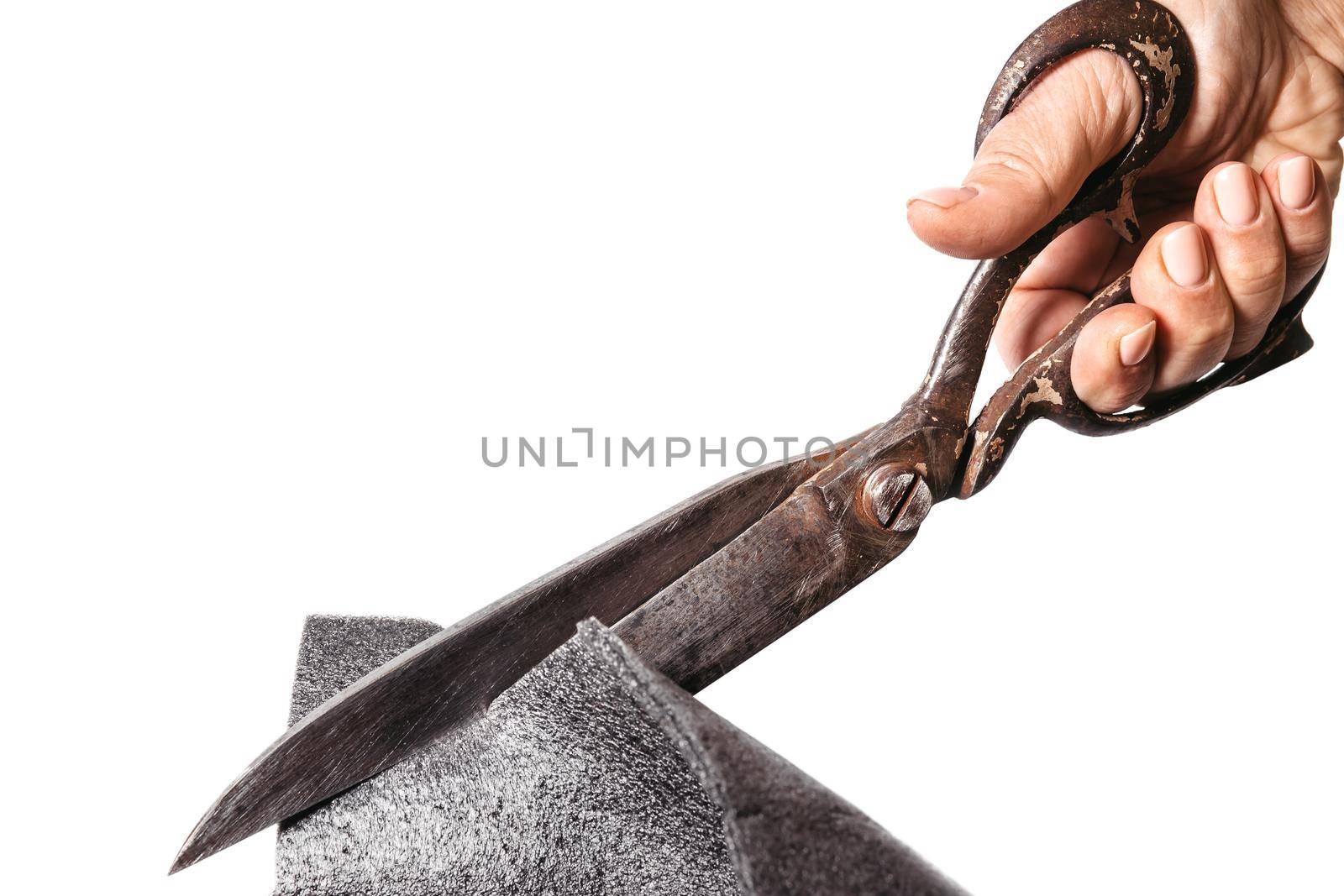 Old scissors cutting thick material on white isolated background