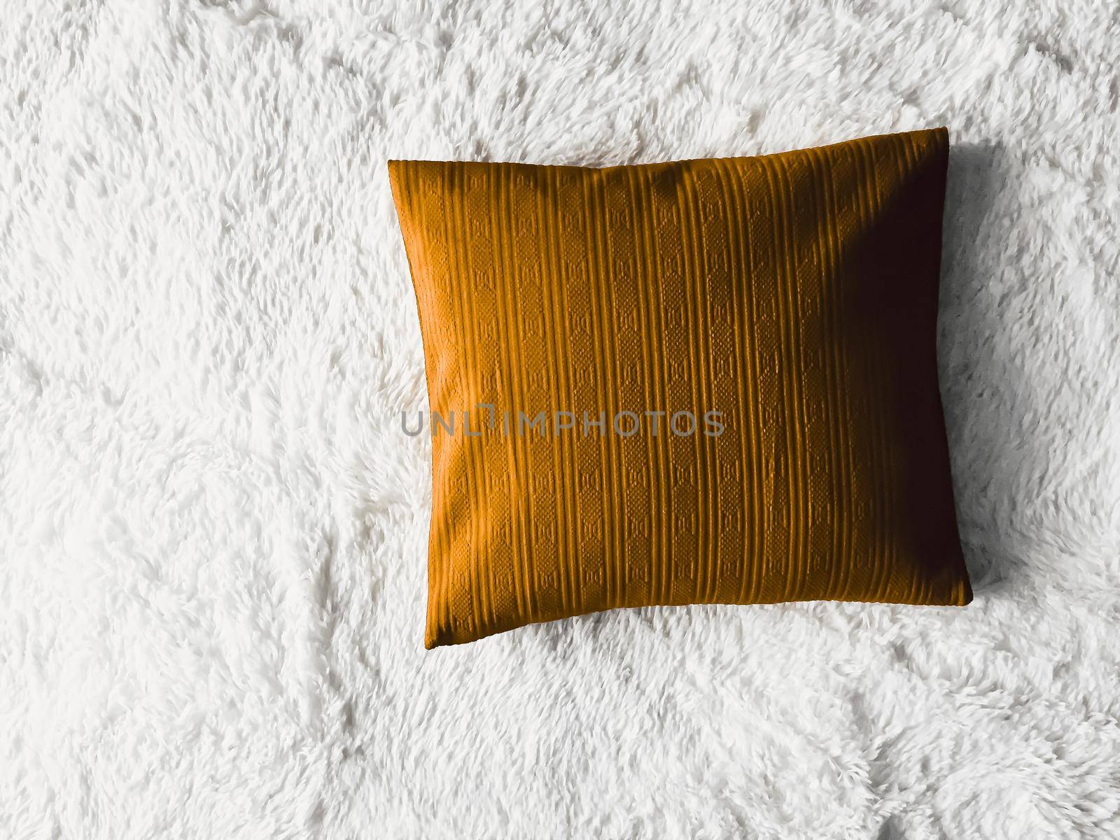 Golden cushion throw pillow on white fluffy plaid blanket as flat lay background, bedroom top view and home decor flatlay