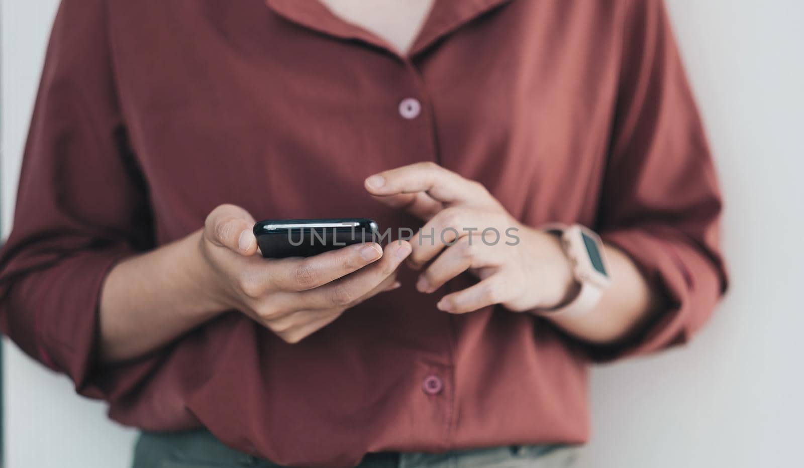 Women's hands use a smartphone for online shopping, social networking, or remote work. Close up image.