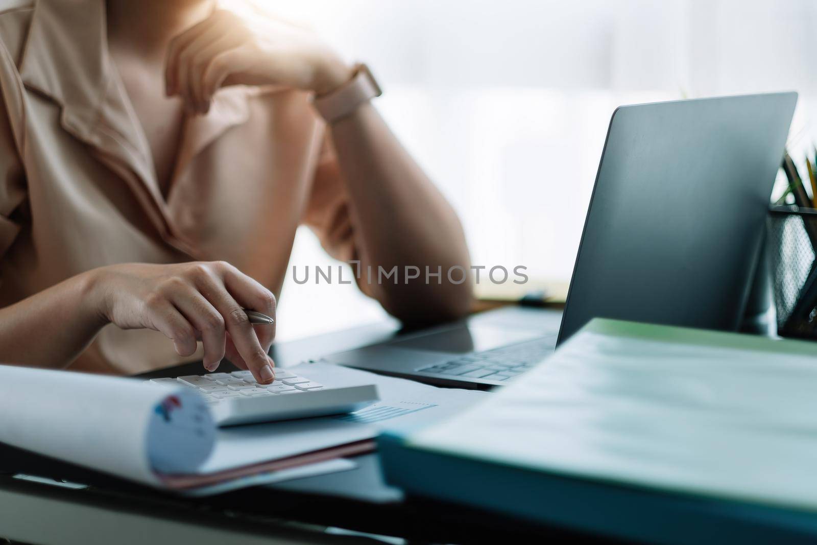 businessman working on desk office with using a calculator to calculate the numbers, finance accounting concept. by nateemee