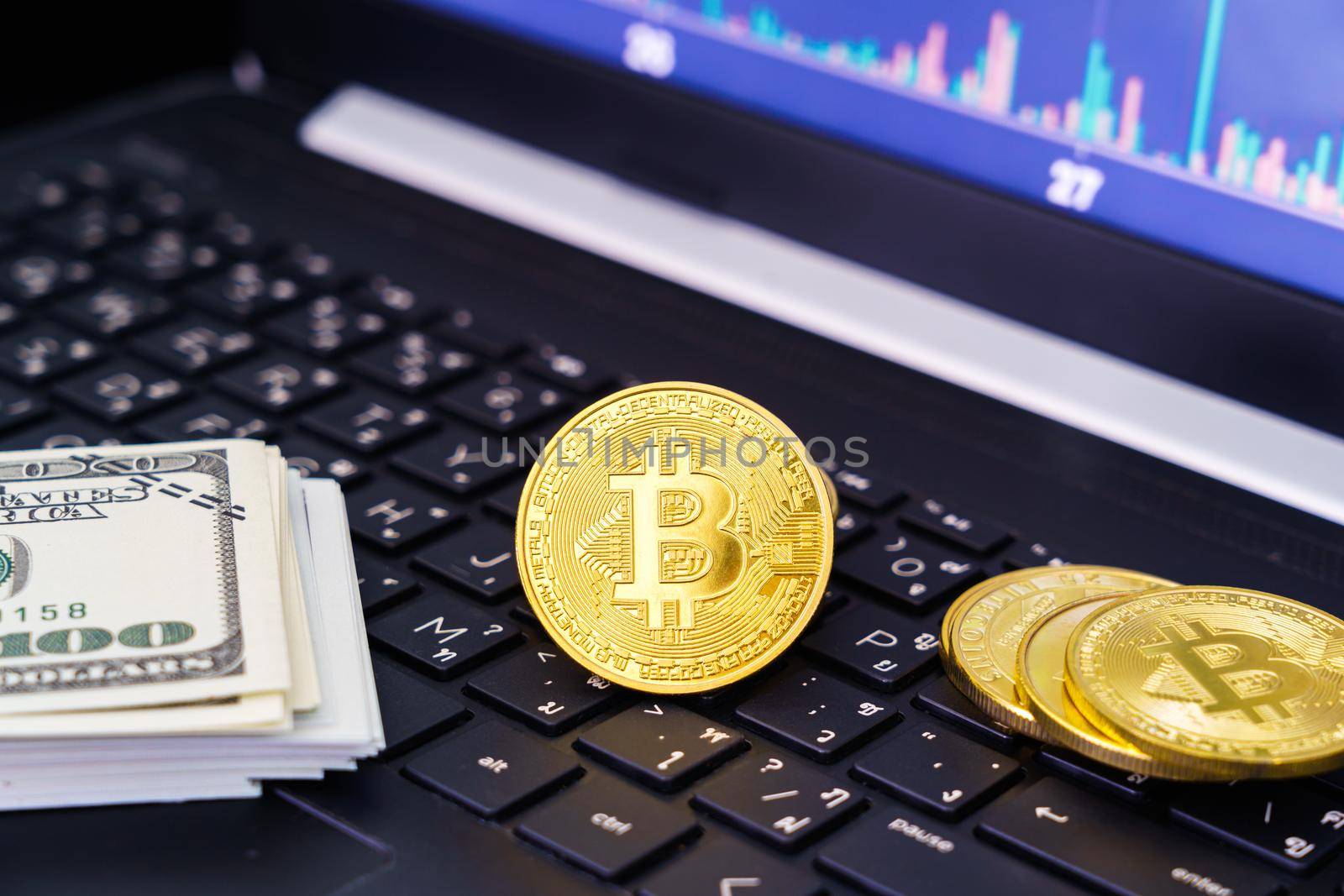 Bitcoins coin and banknotes on keyboard computer. Close up of  bitcoin crypto currency coins with trading exchange market price chart in the background