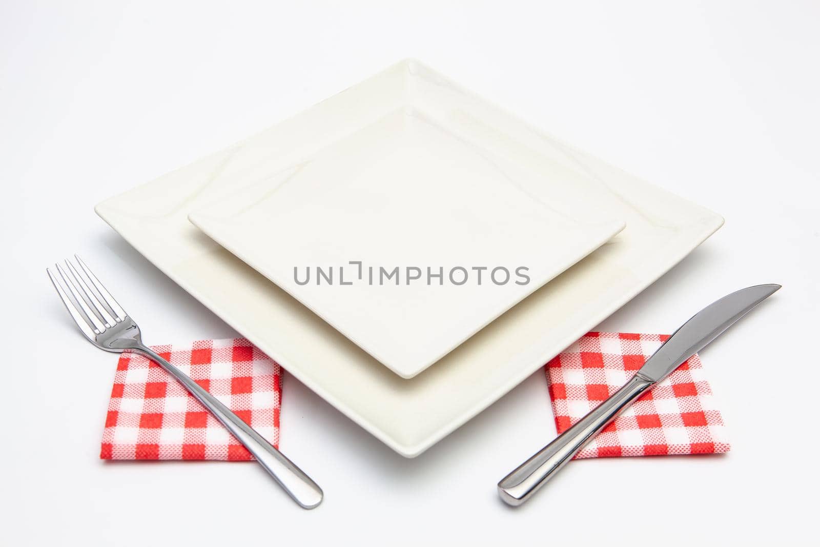White square plate on the white wooden table.Top view.Flat Lay Image.