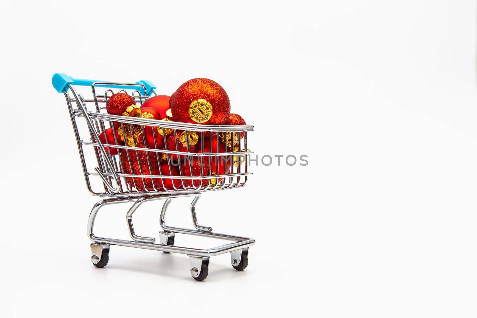 Shopping trolley full of red Christmas balls  on the white background