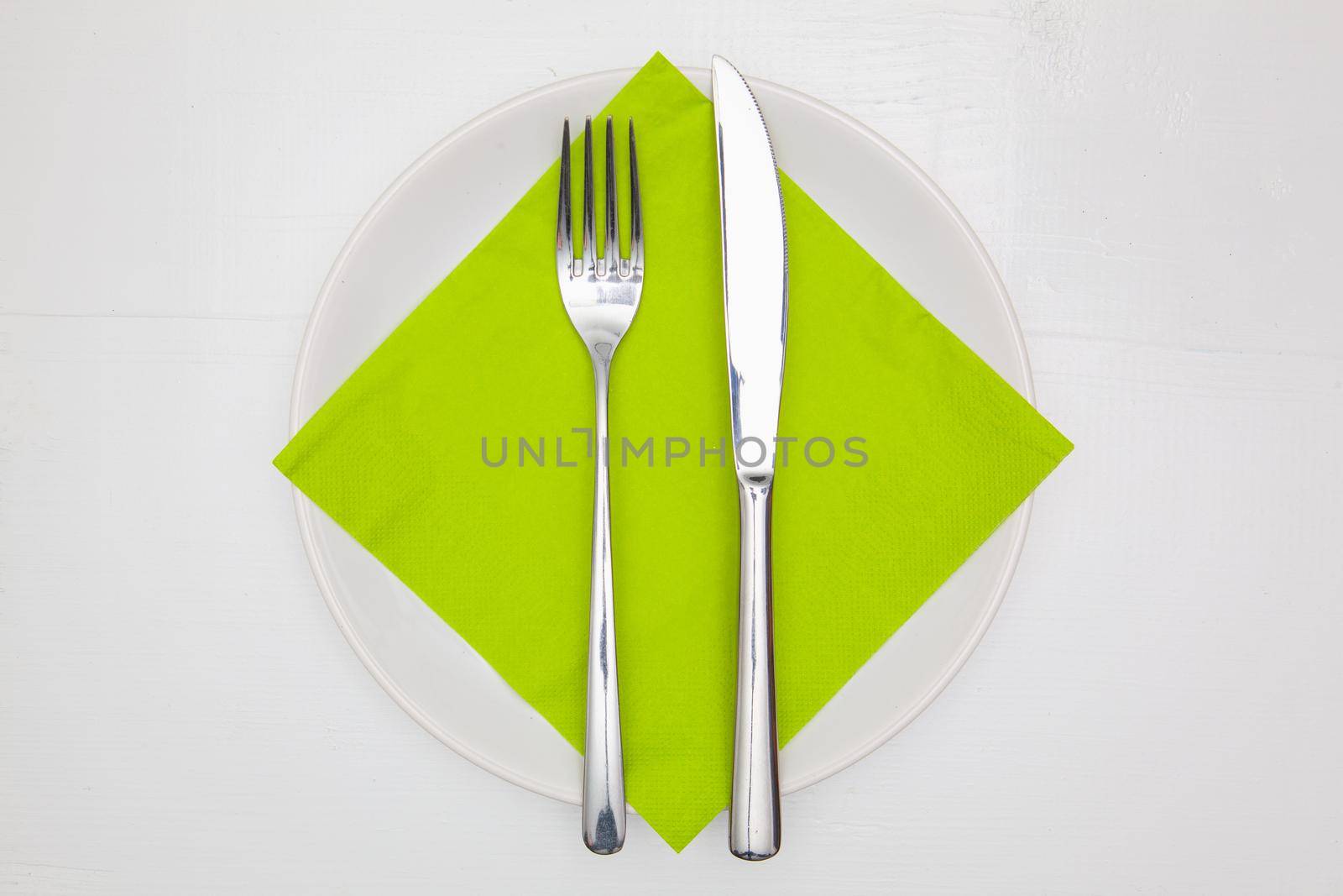 White square plate and green Christmas decoration on the white  wooden table.Top view.Flat Lay Image.