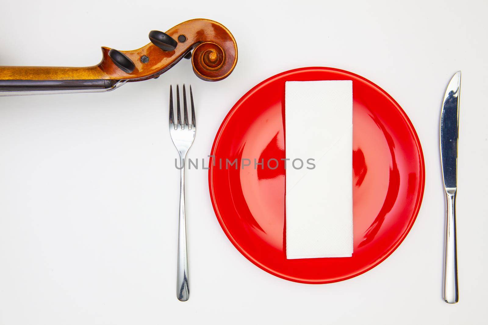 Symphony of taste. Red plate and old violin on the white  wooden table.Top view. Flat Lay Image.