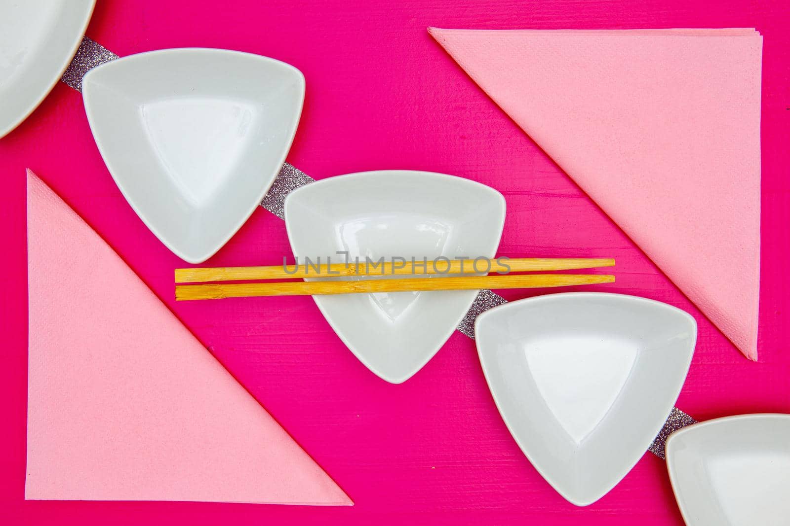 Ceramic bowls  and bamboo chopsticks for sushi food with on the pink wooden table.Top view. Flat Lay Image.