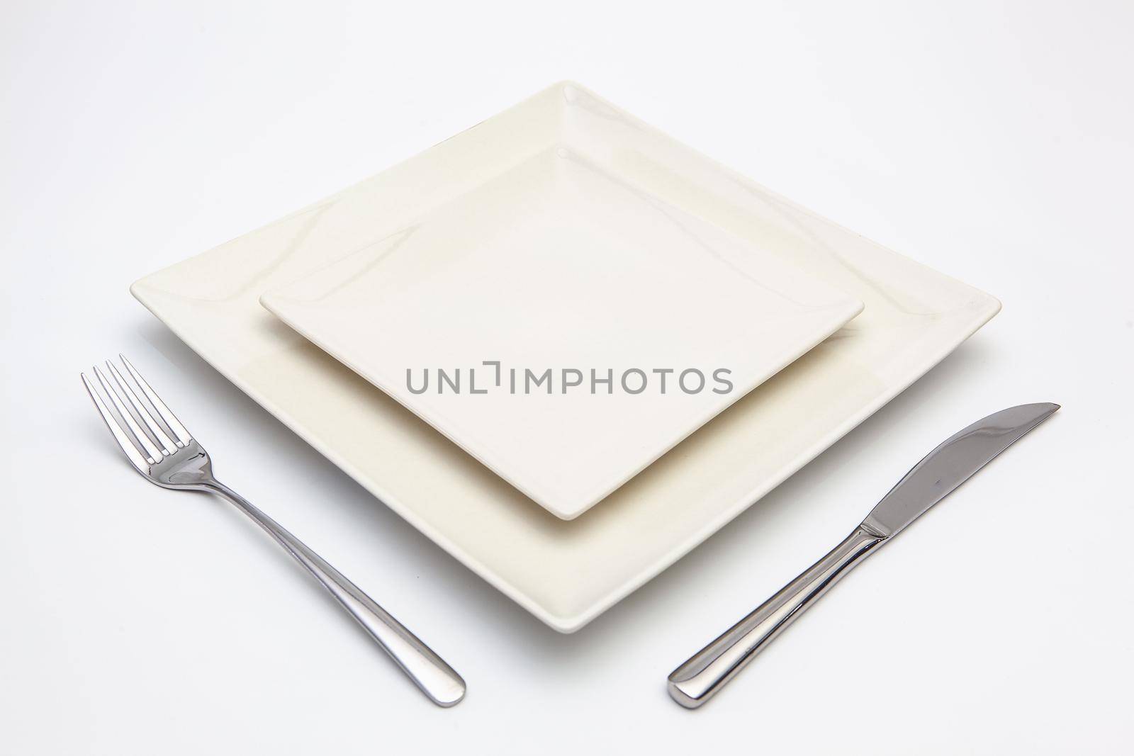 White square plate on the white wooden table. by CaptureLight