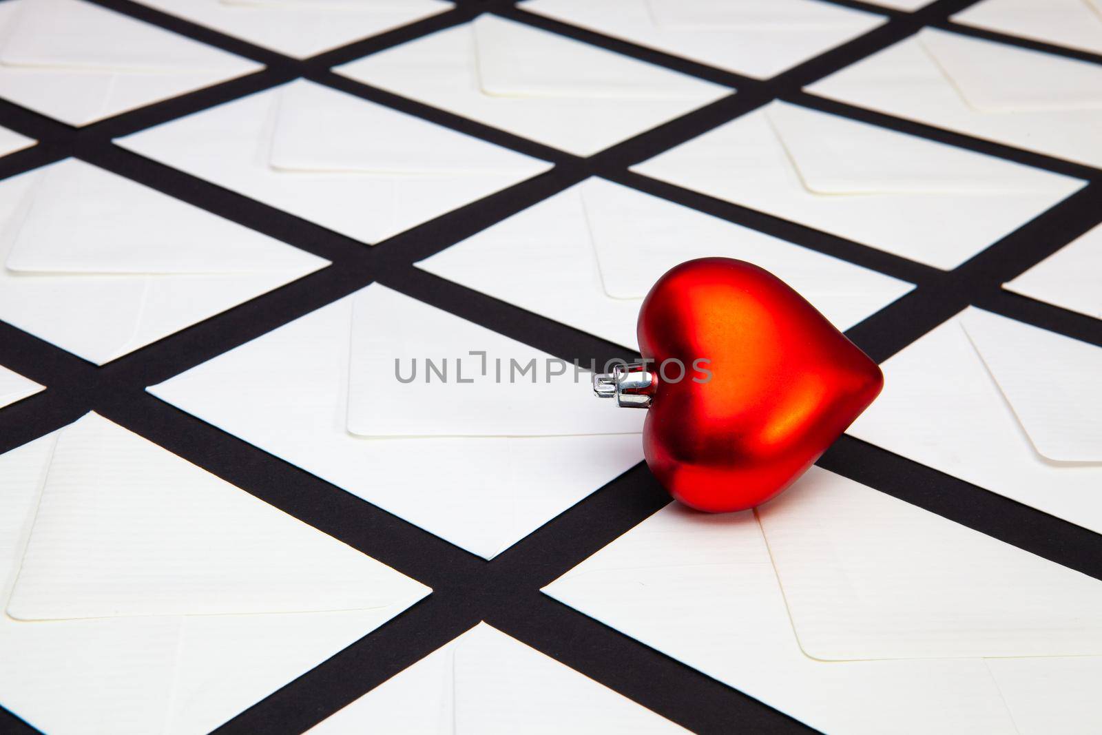 Composition with white envelopes and red heart on the table. The photo suitable for various holidays and anniversaries.