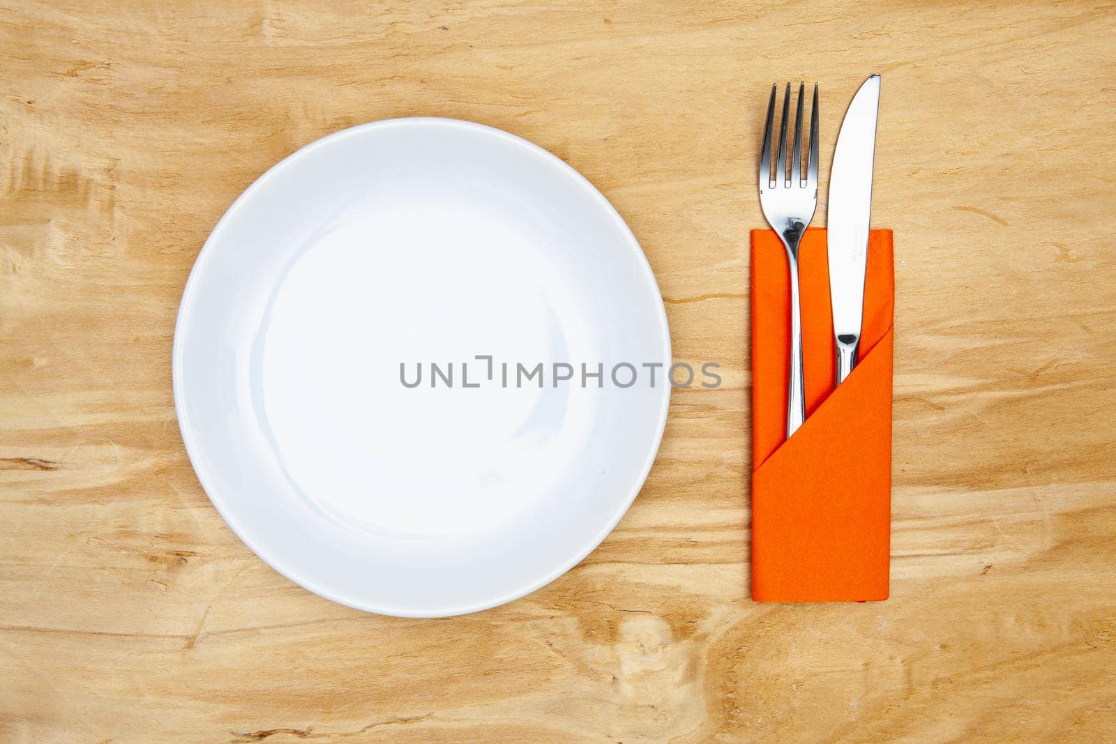 White plate on the wooden table.Top view. Flat Lay Image.