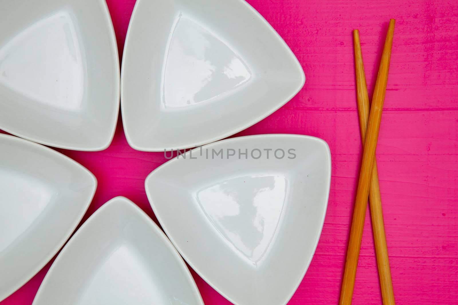 Ceramic bowls  and bamboo chopsticks for sushi food with on the pink wooden table.Top view. Flat Lay Image.