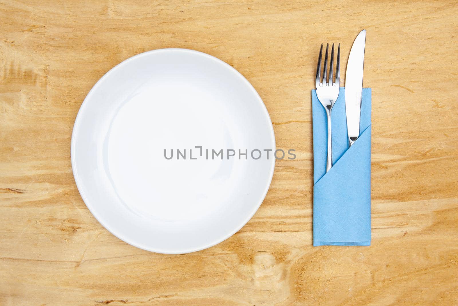 White plate on the wooden table.Top view. Flat Lay Image.