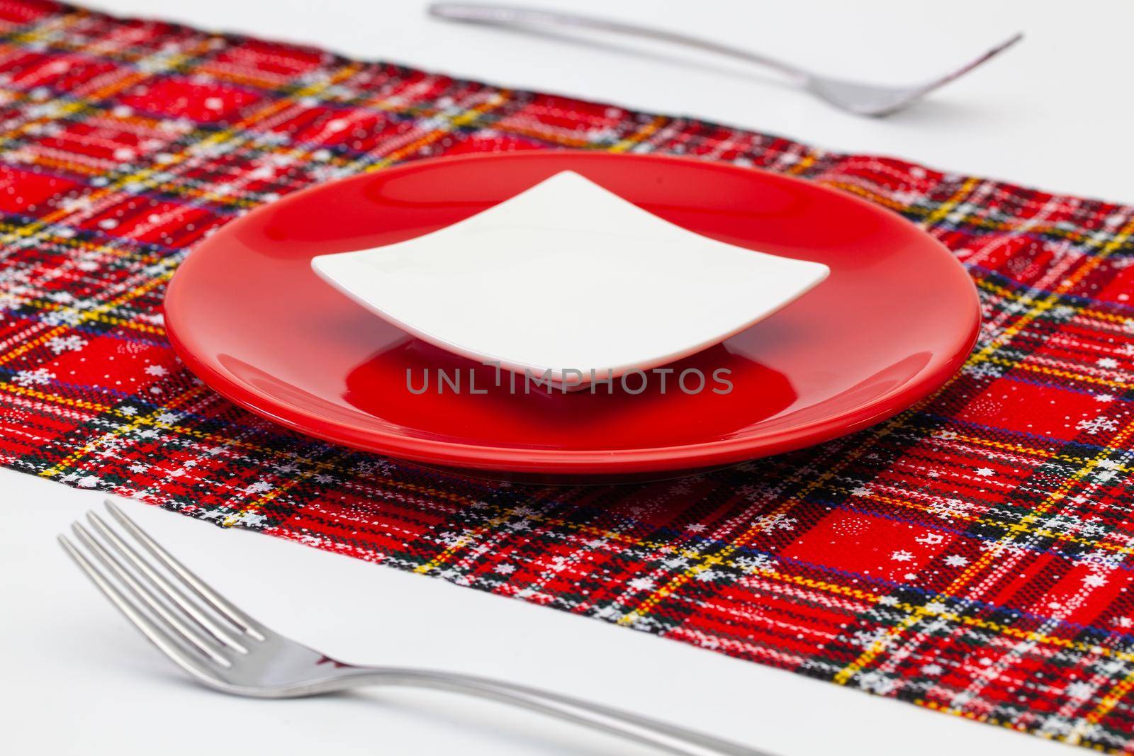 Red plate and Christmas decoration on the white wooden table. by CaptureLight