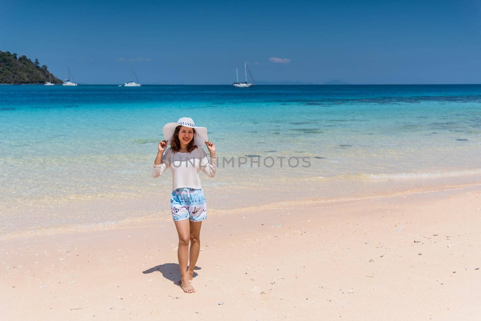 Happy young woman enjoying on beach by Sorapop