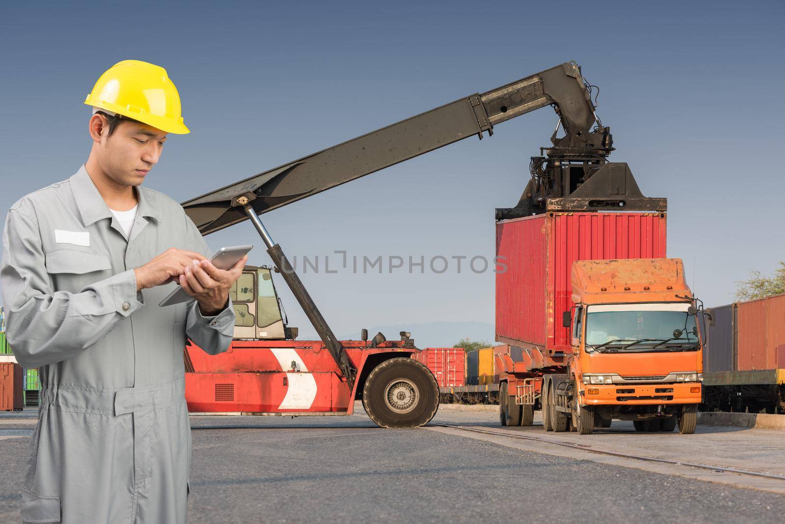 Foreman stand check tablet on front forklift loading Containers box to Logistic cargo Import Export