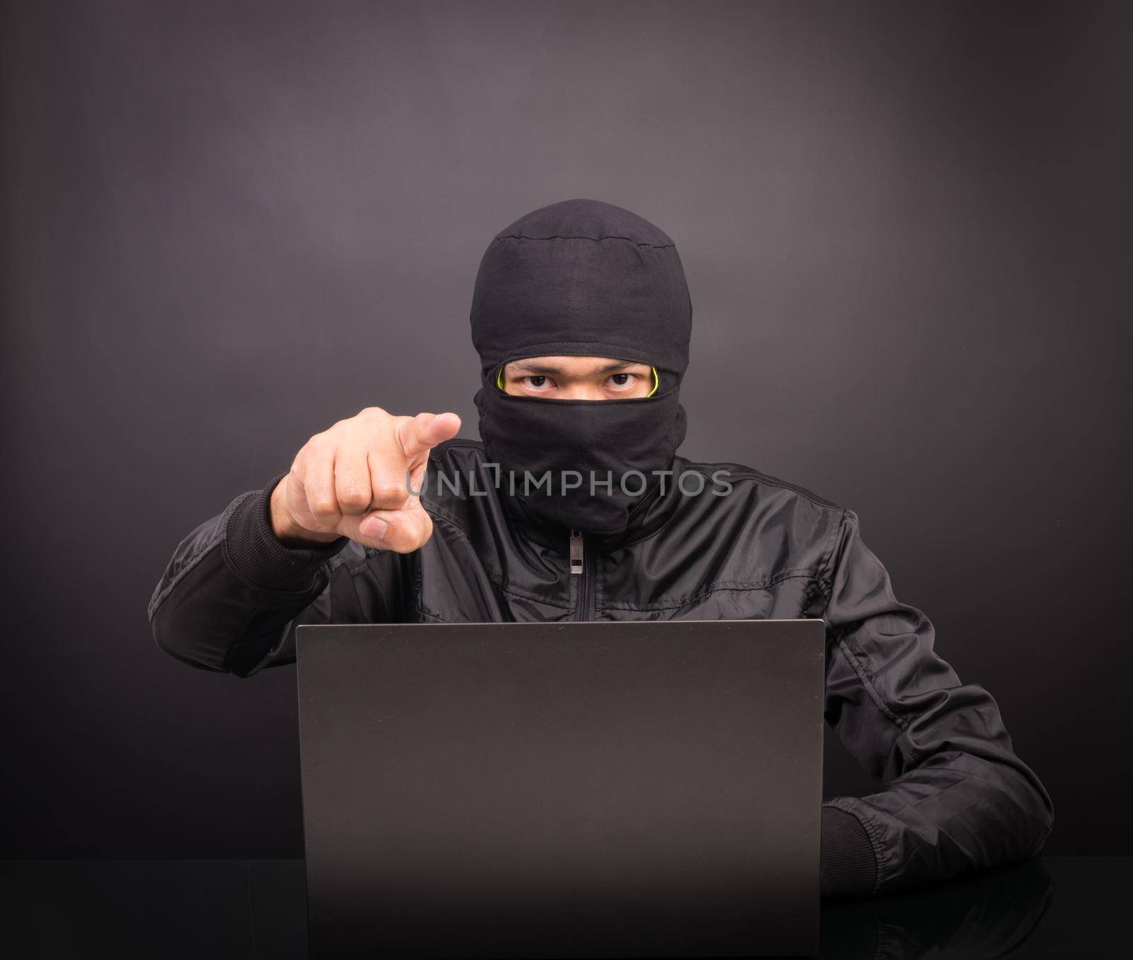 Laptop computer hacker point hand - Male thief stealing data from laptop computer on black background
