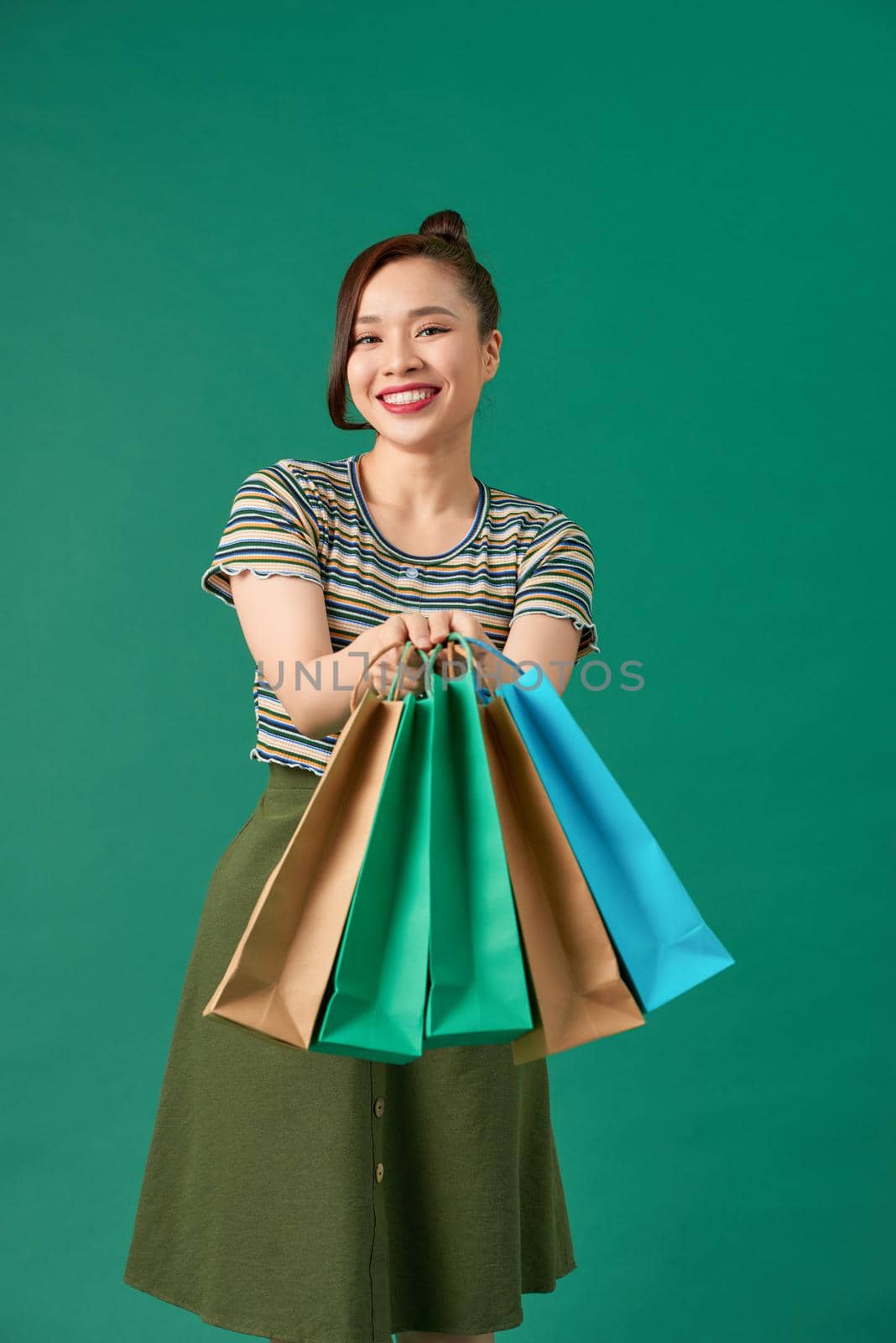 Stylish asian woman smiling and holding shopping bags 