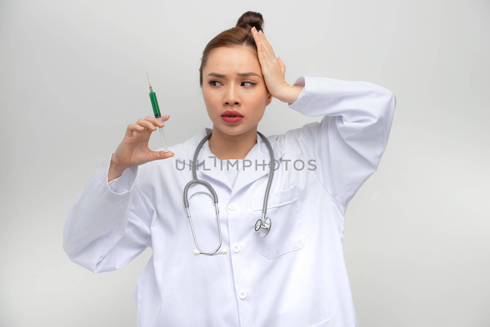 Professional doctor woman holding syringe with medical vaccine stressed with hand on head, shocked with shame and surprise face by makidotvn
