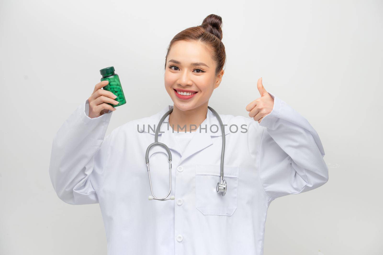 happy woman showing thumb up and holding bottle with pills