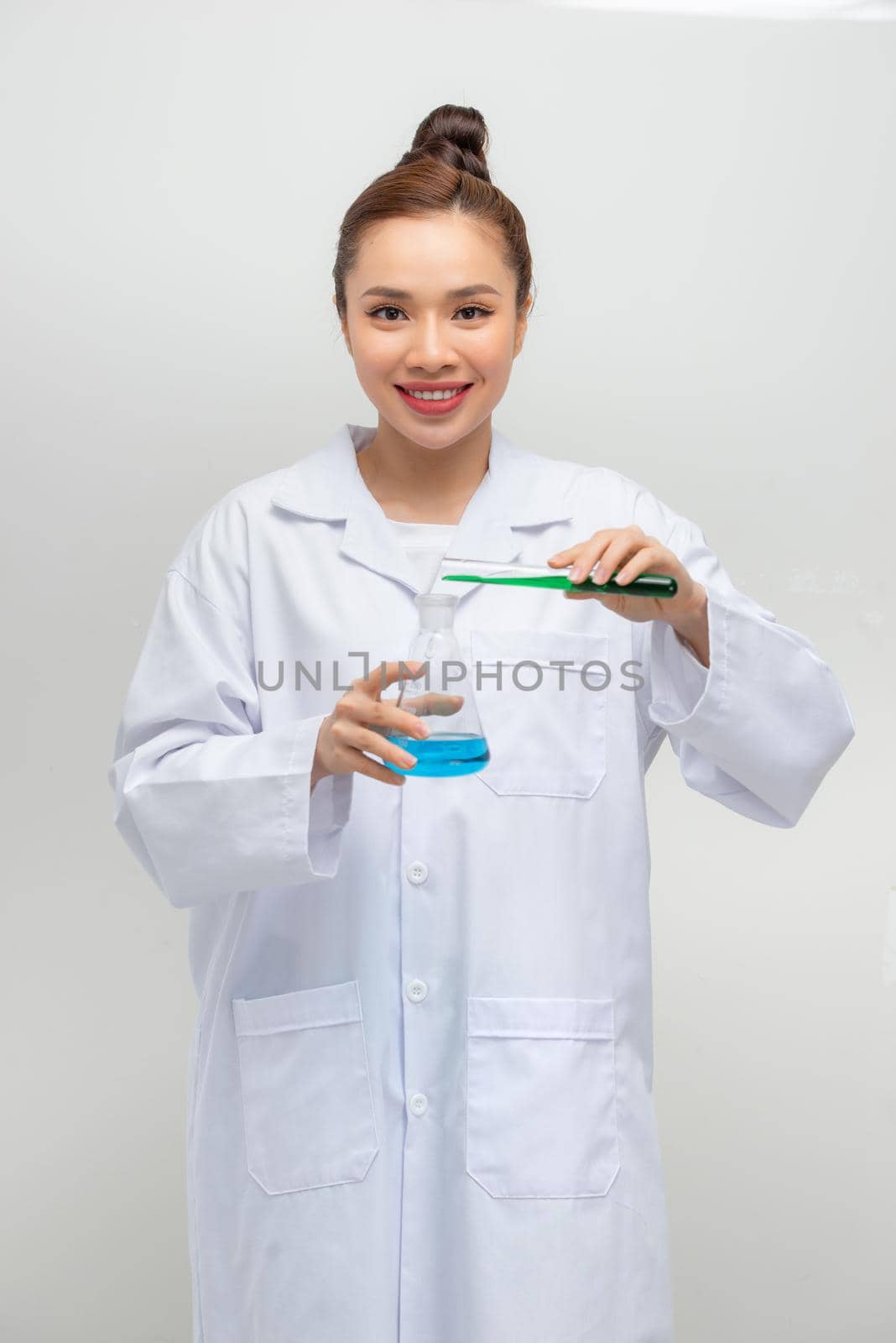 a female pharmacist mixing chemical liquids on medical scales in a laboratory