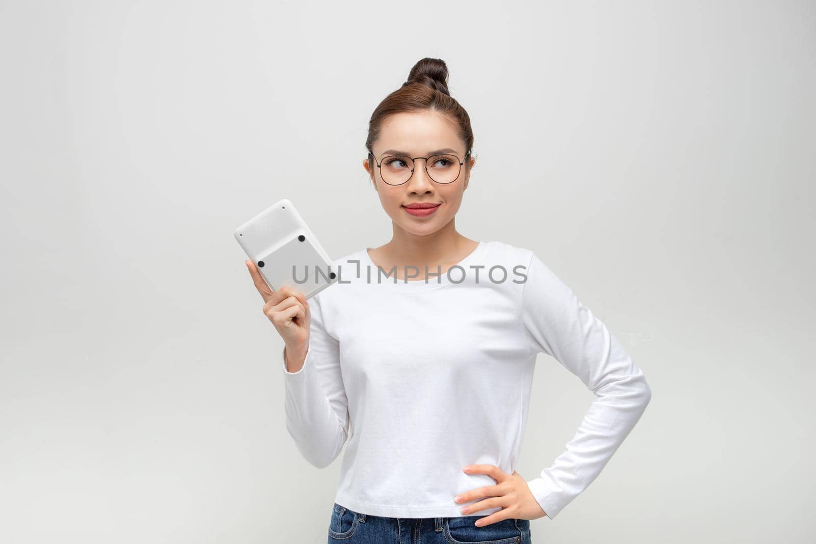 young woman looking at the camera with a calculator in hand by makidotvn