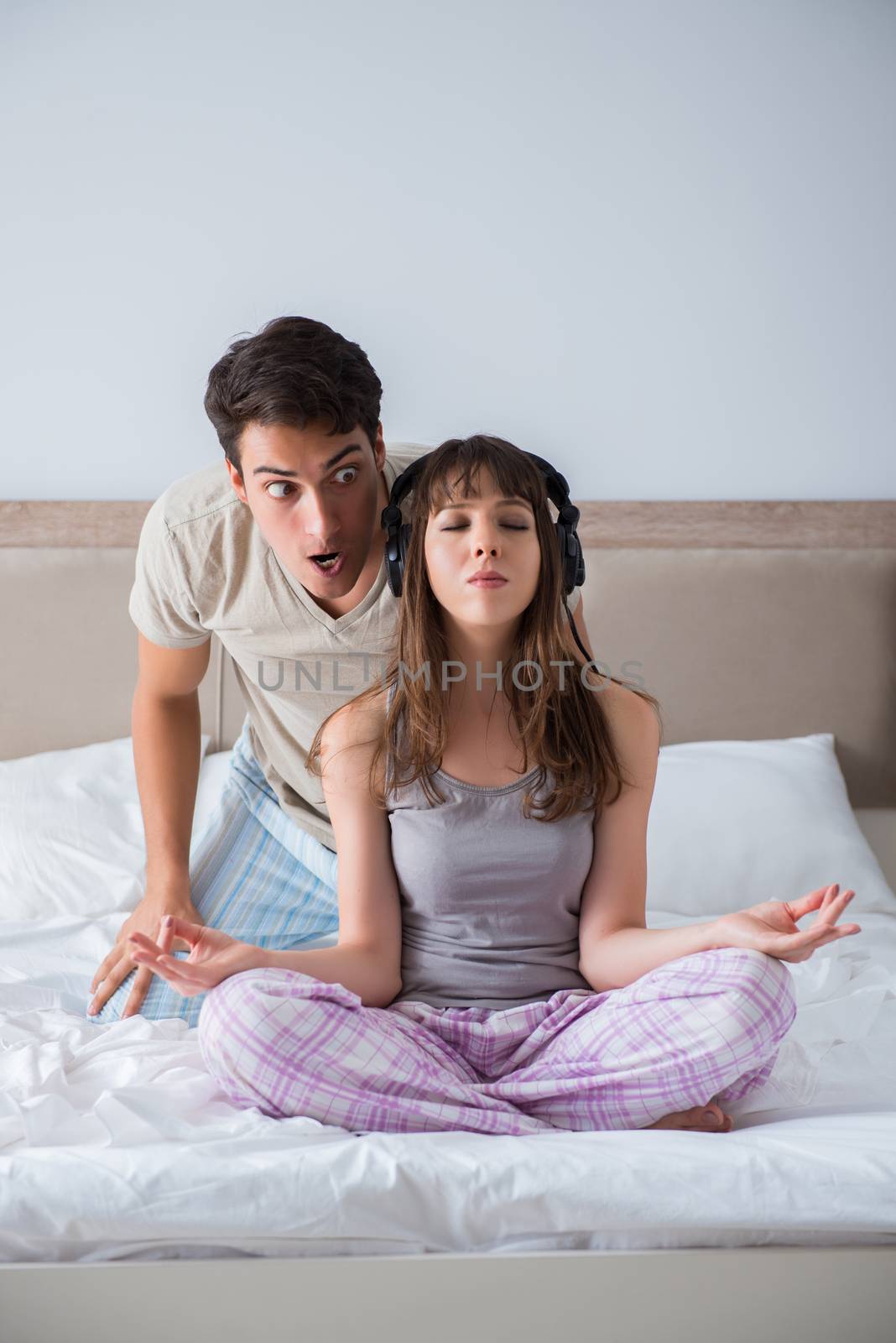 Young family meditating in the bed bedroom by Elnur