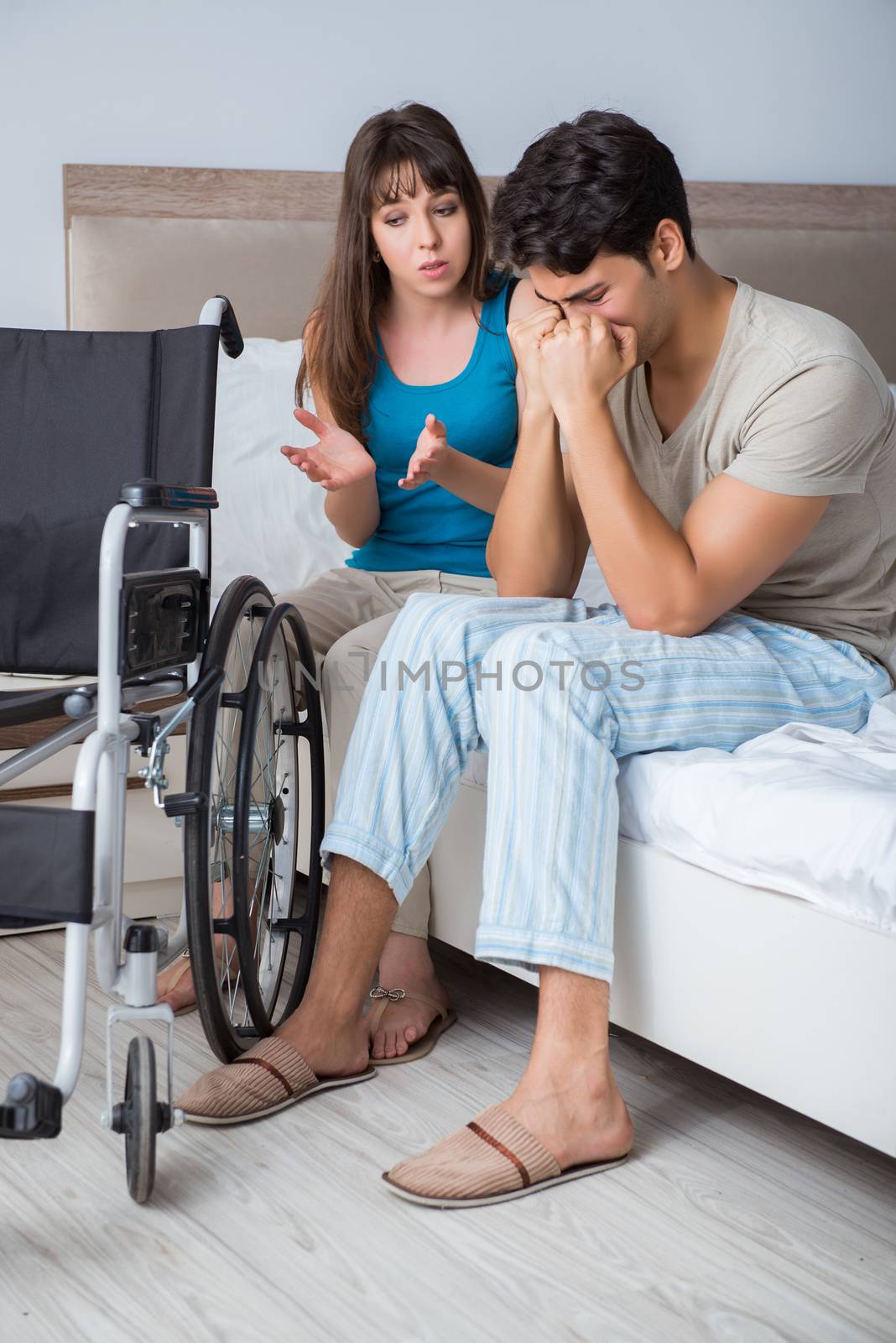 Desperate man on wheelchair with his sad wife