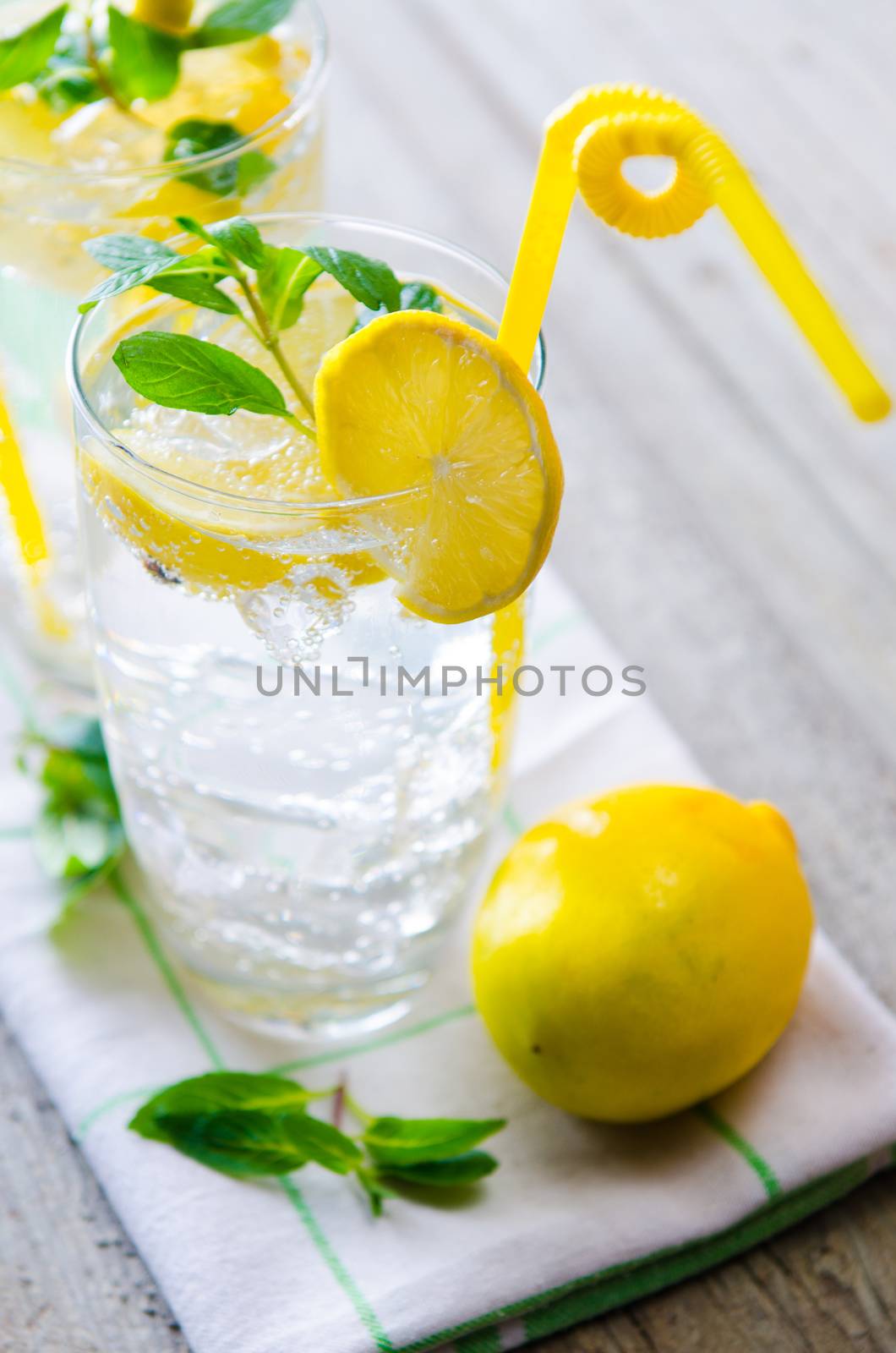 Glasss of mojito with lemon and drinking straw