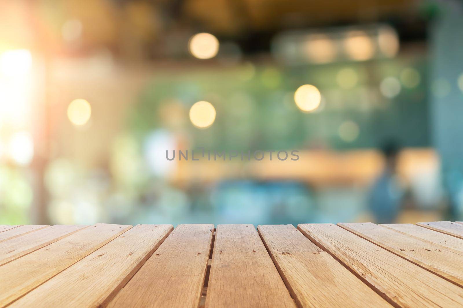 Selective focus of wooden table with blur coffee and restutant cafe with customers background.