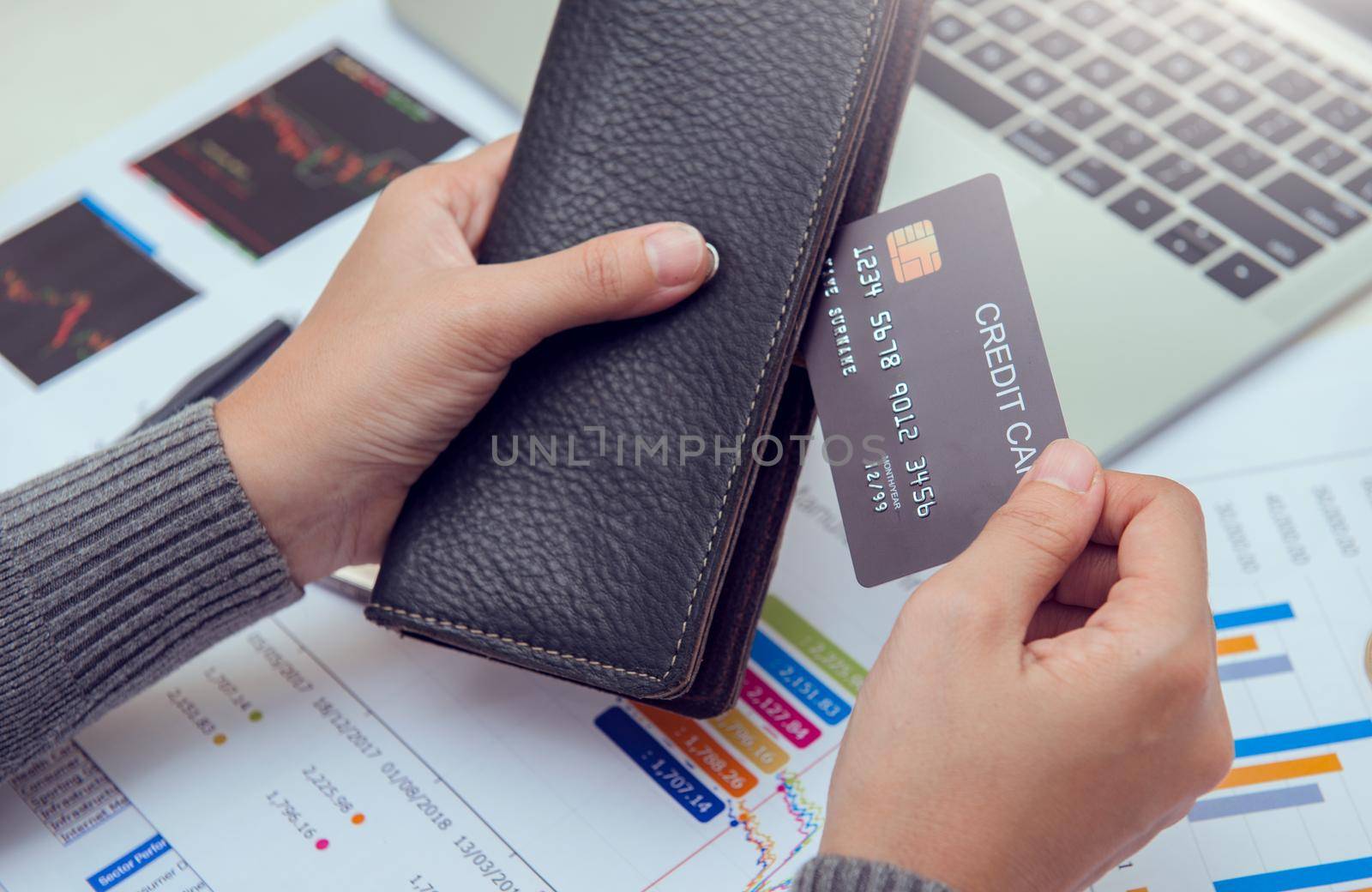 Businesswoman hands holding leather wallet with credit cards on office desk. Business, finances and money concept.