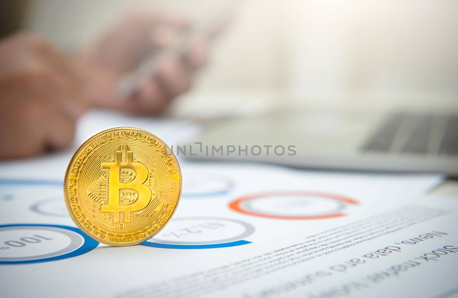 Close-up golden bitcoin on the office desk with businessman working background.