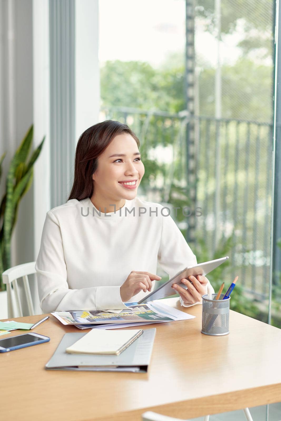 Beautiful asian woman using tablet in bright room