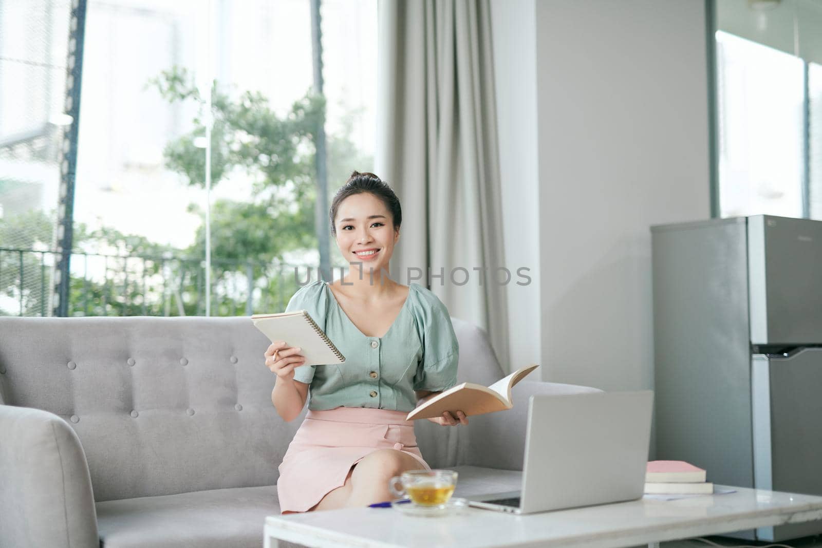 Photo of focused business woman hold pen sit sofa write notes fingers specs in home workstation indoors by makidotvn