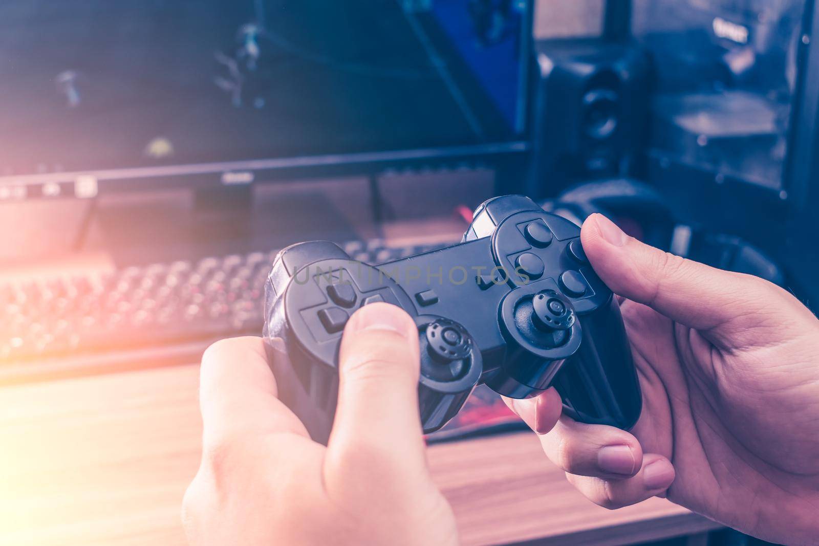 Man holding a game joystick while playing a video game